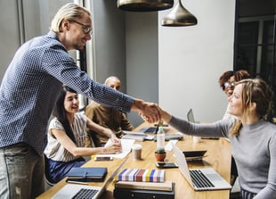 man shaking heads with co-worker during a meeting