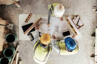 construction workers looking over construction plans on a construction site